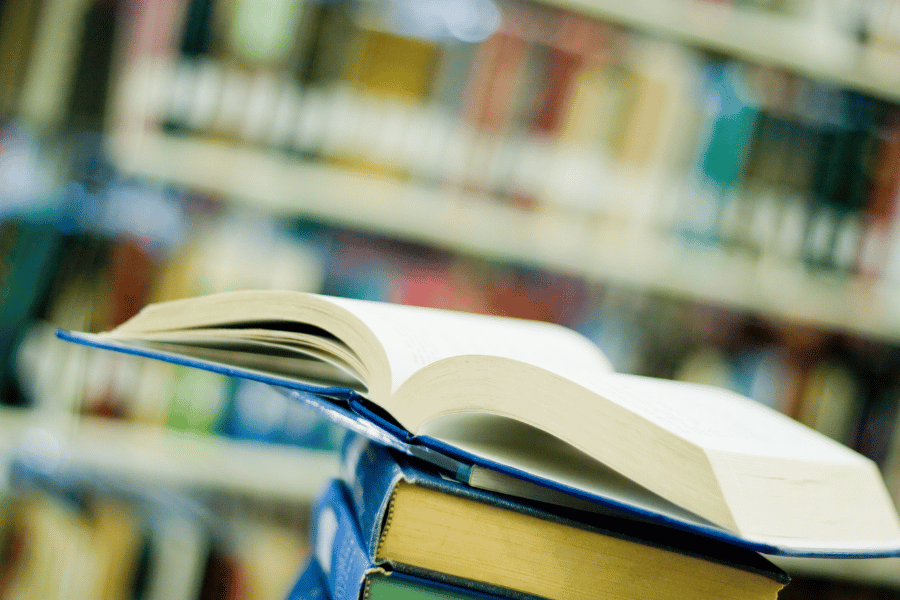 open book on stack of books at a public library 