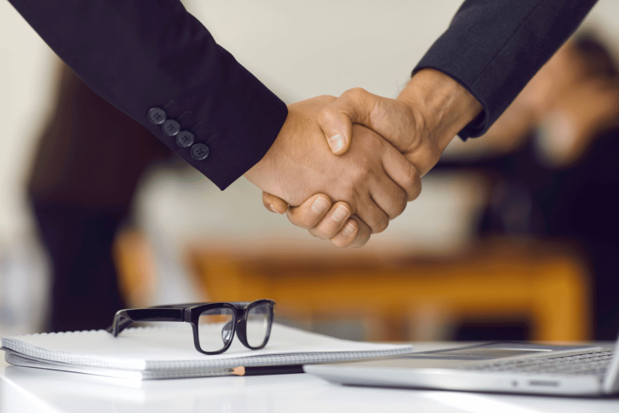 two realtors shaking hands and collaborating 