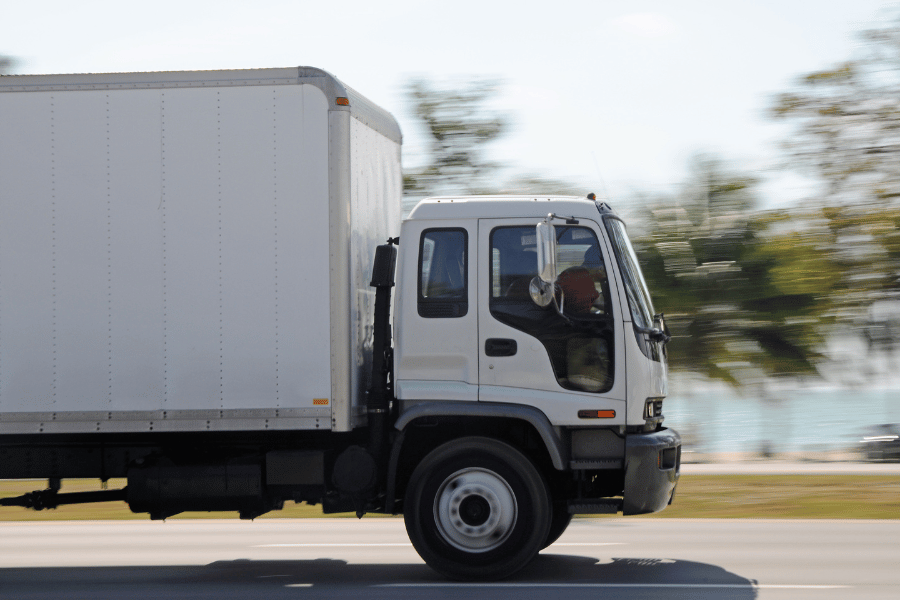 white moving truck driving cross-country 