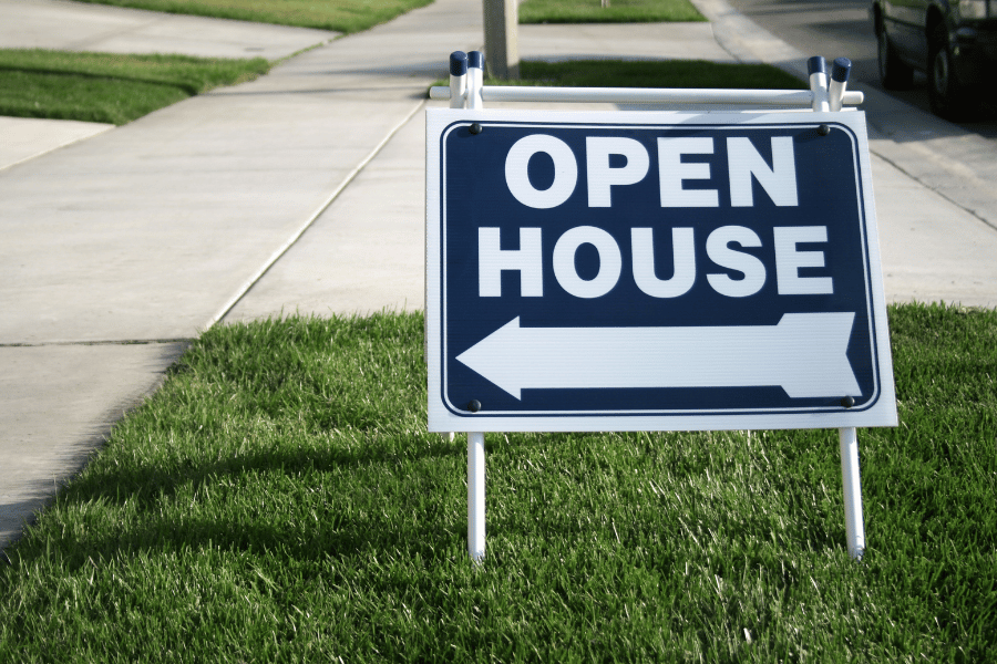 blue and white open house sign outside of house in the lawn