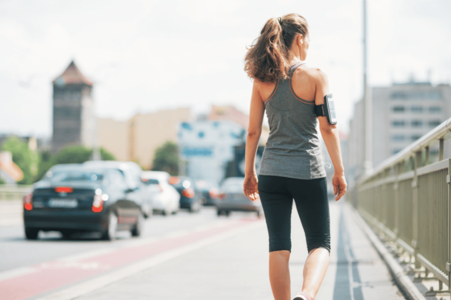 woman walking in the city on a sidewalk during the day