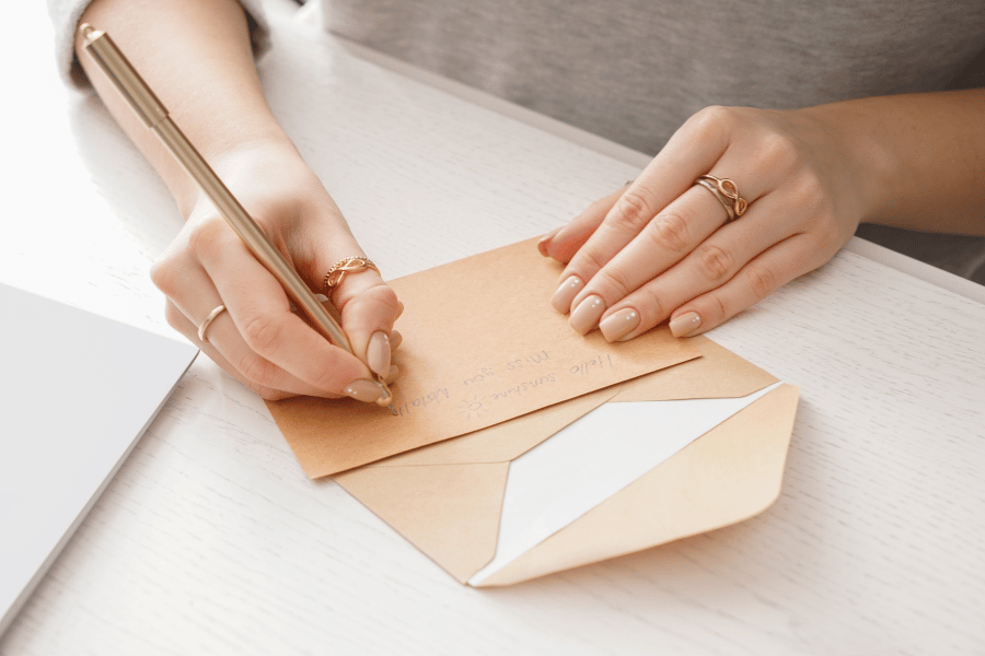 woman writing a personalized letter with a pen 
