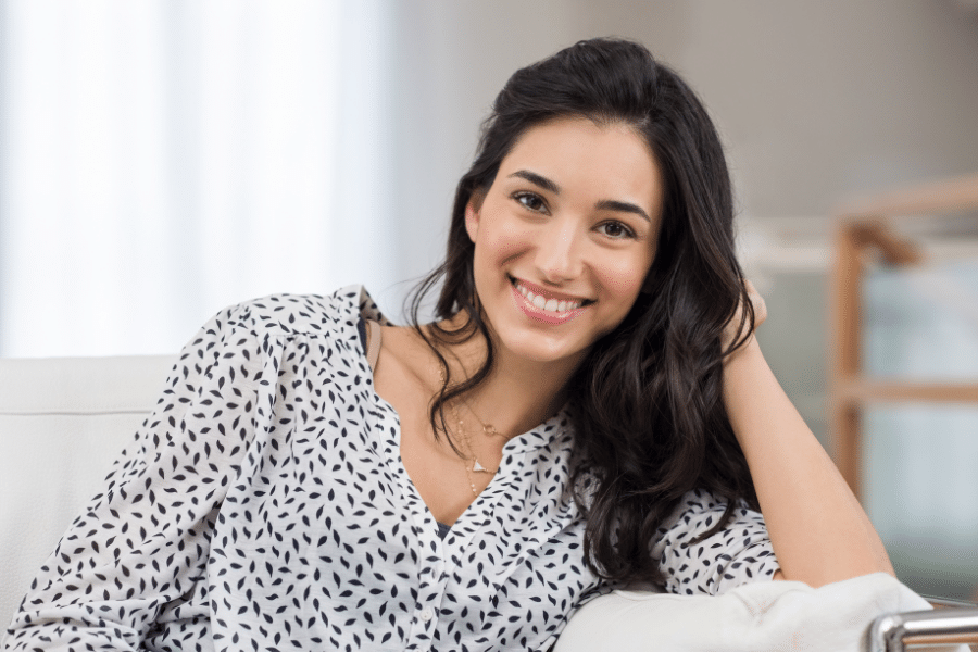 happy young woman smiling on the couch 