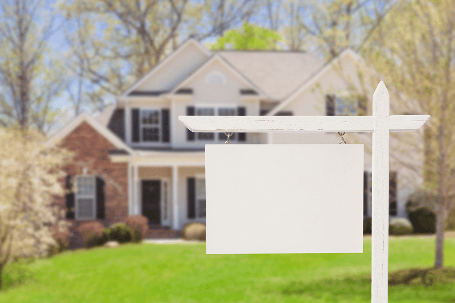 Real estate sign in front of house promoting agent