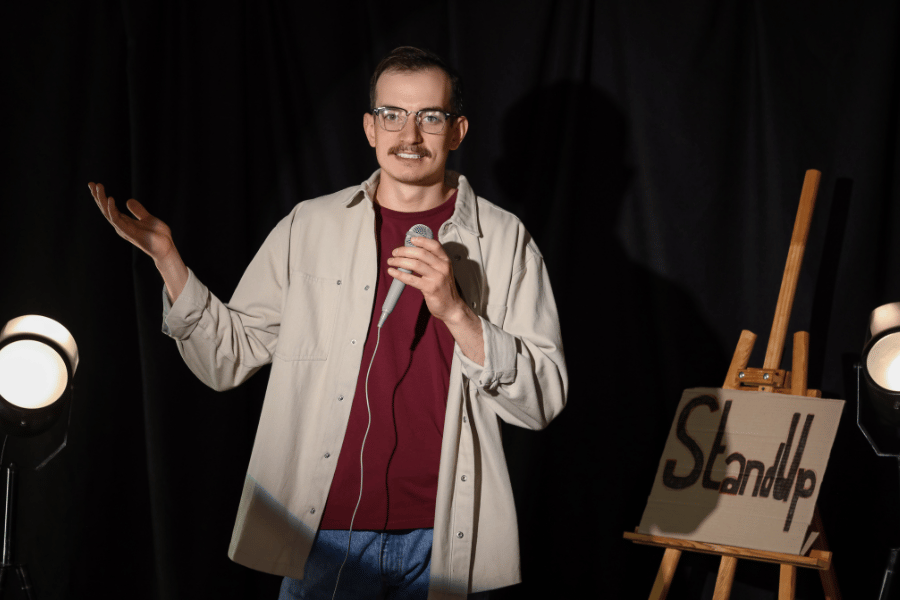 stand up comedian performing on stage with a microphone