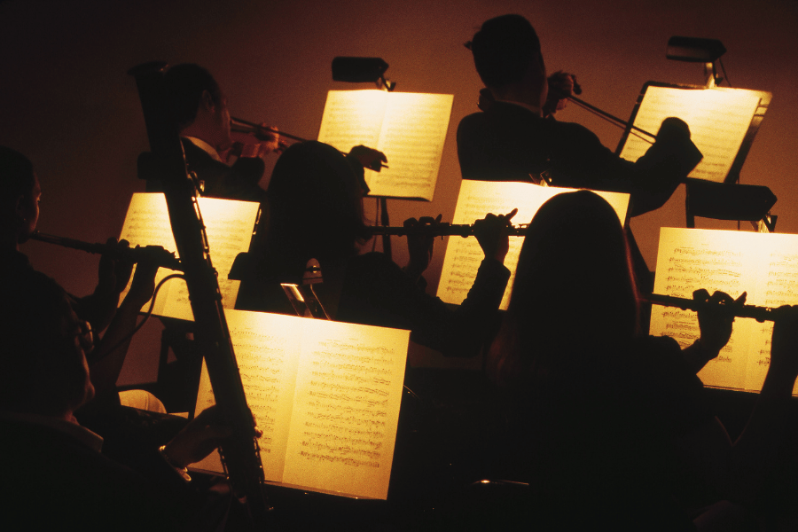 Symphony Orchestra playing with sheet music lit up 