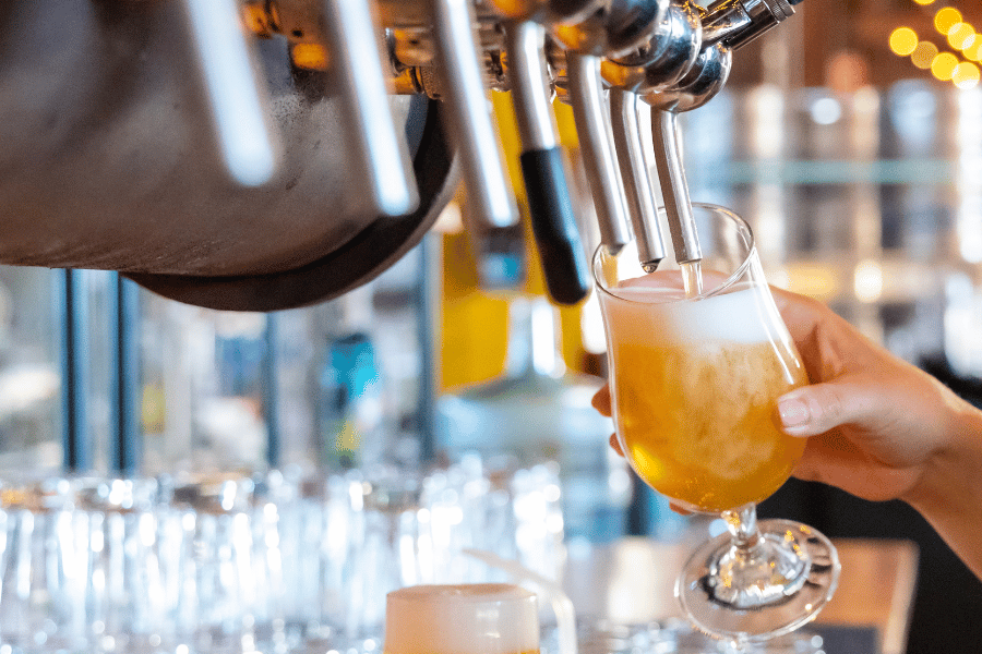Pouring craft beer into glass from a tap 