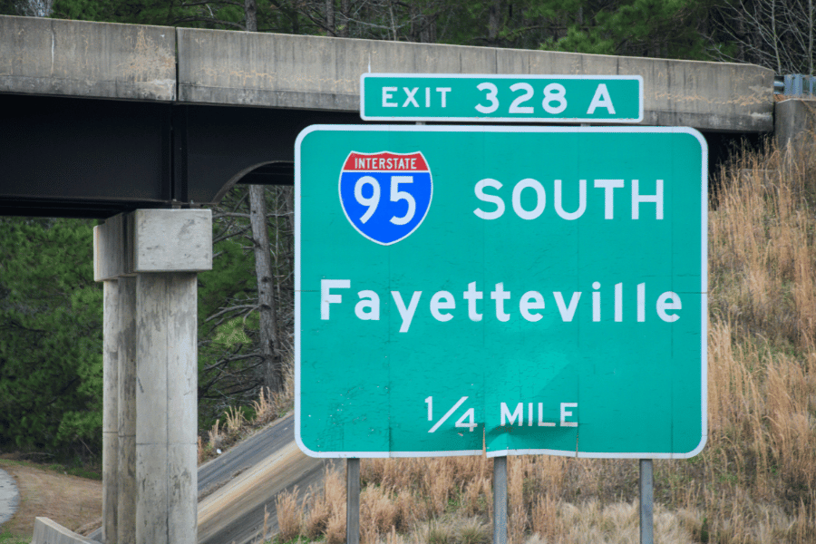 Green road sign of Fayetteville, NC on the highway 