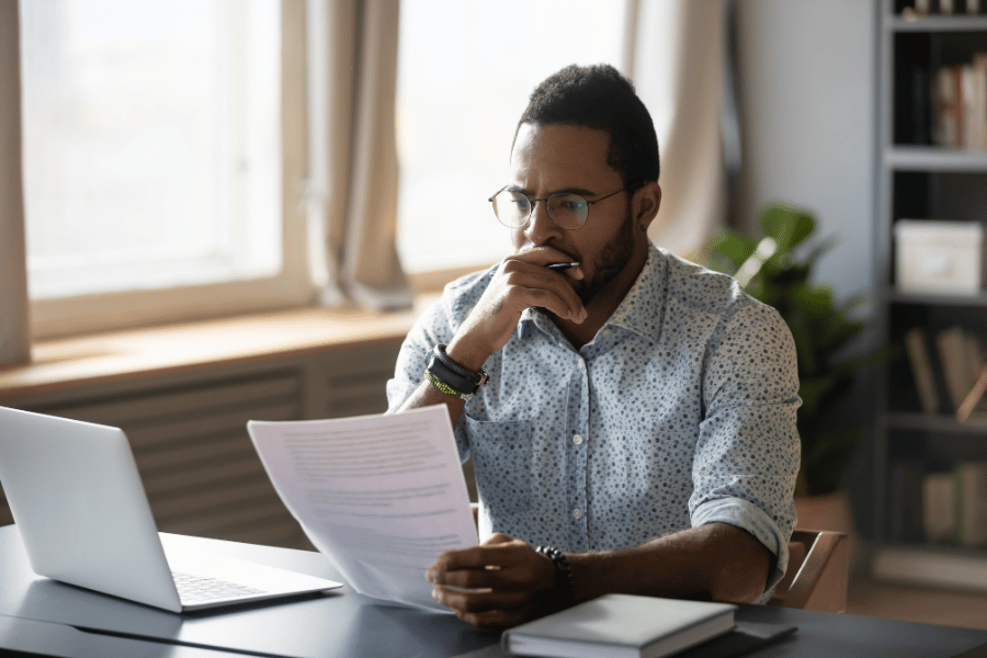 Man conducting research on home buying companies with laptop 