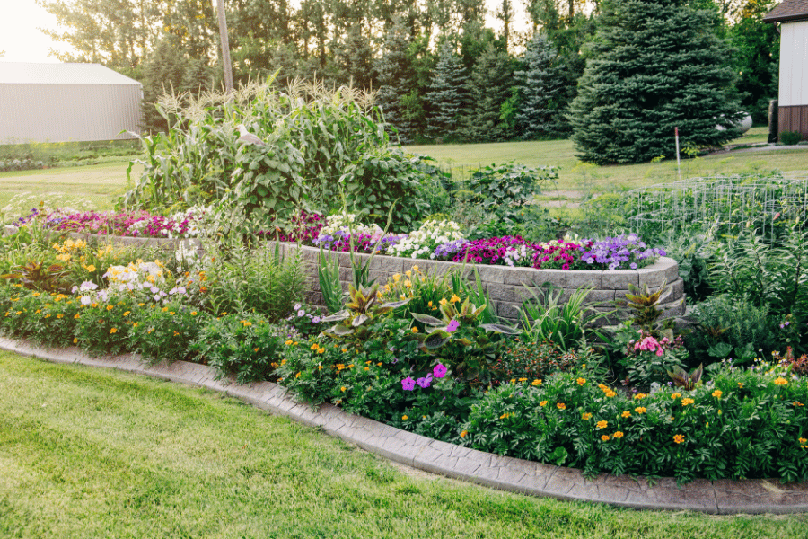 beautiful flowers and plants in a garden bed in front of house