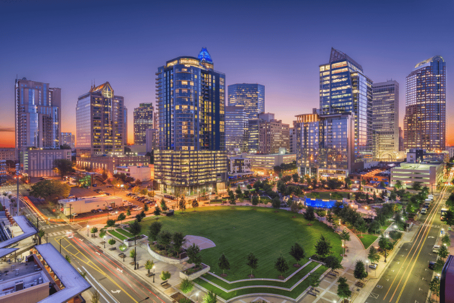 Skyline of Charlotte, NC buildings lit up at dusk 