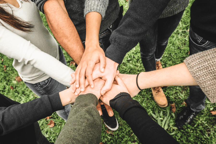 group of volunteers putting hands together 