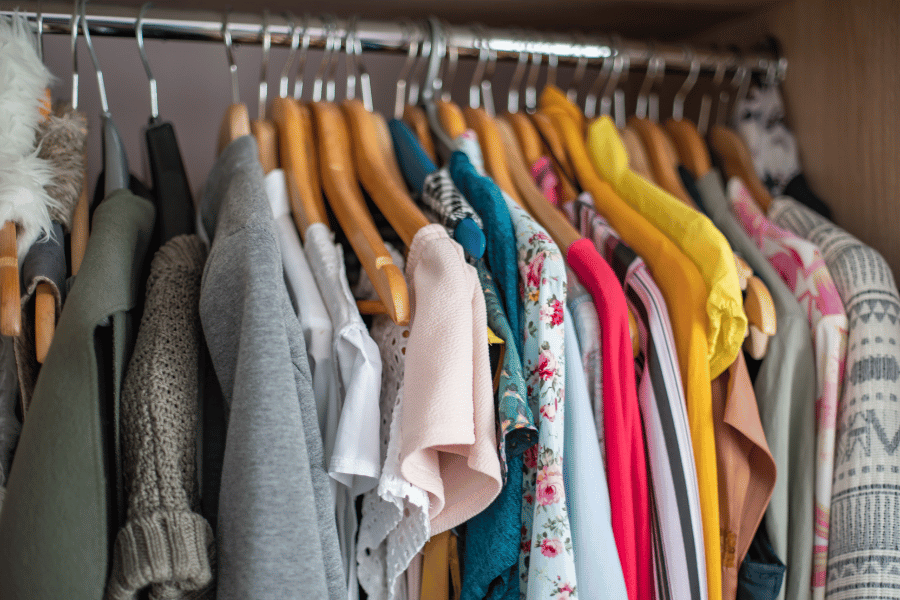 clothes hanging on clothing rack in a closet