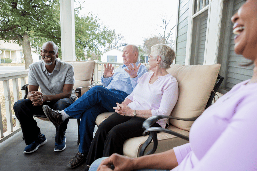 neighbors laughing and talking on the front porch