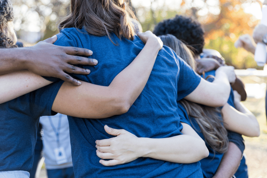 volunteers at a charity event hugging kids and working together