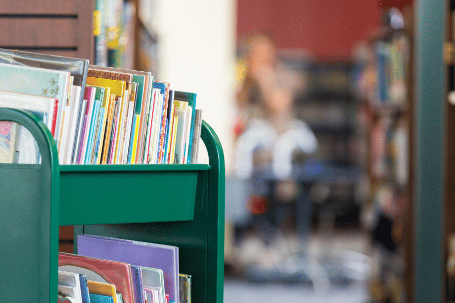 green public library book cart full of books 