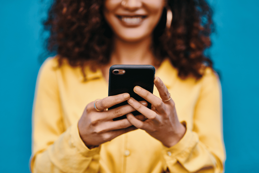 Woman in yellow shirt using social media on the phone