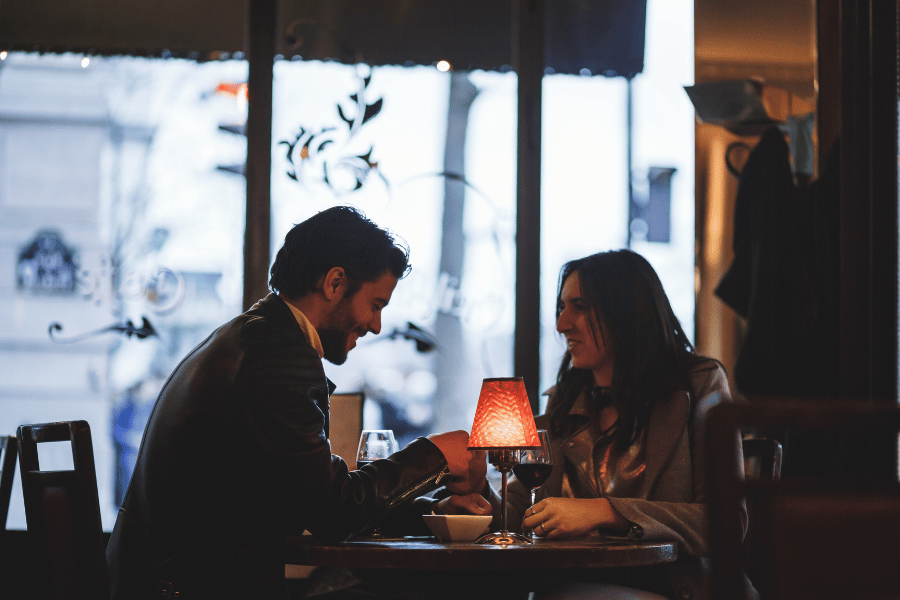 couple enjoying a romantic dinner with wine and intimate lighting